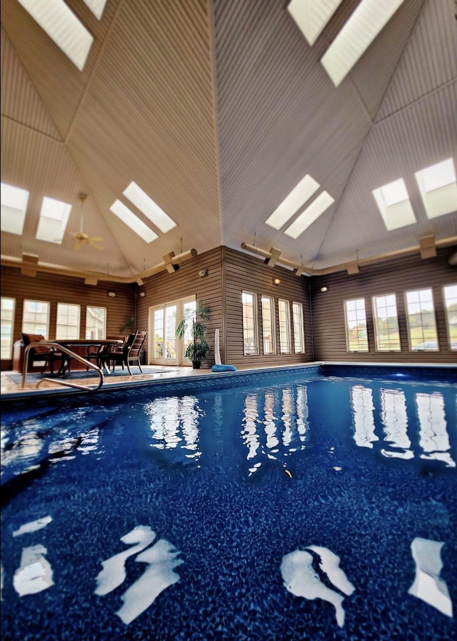 Indoor pool room with skylights, serviced by Island Pools and Spas